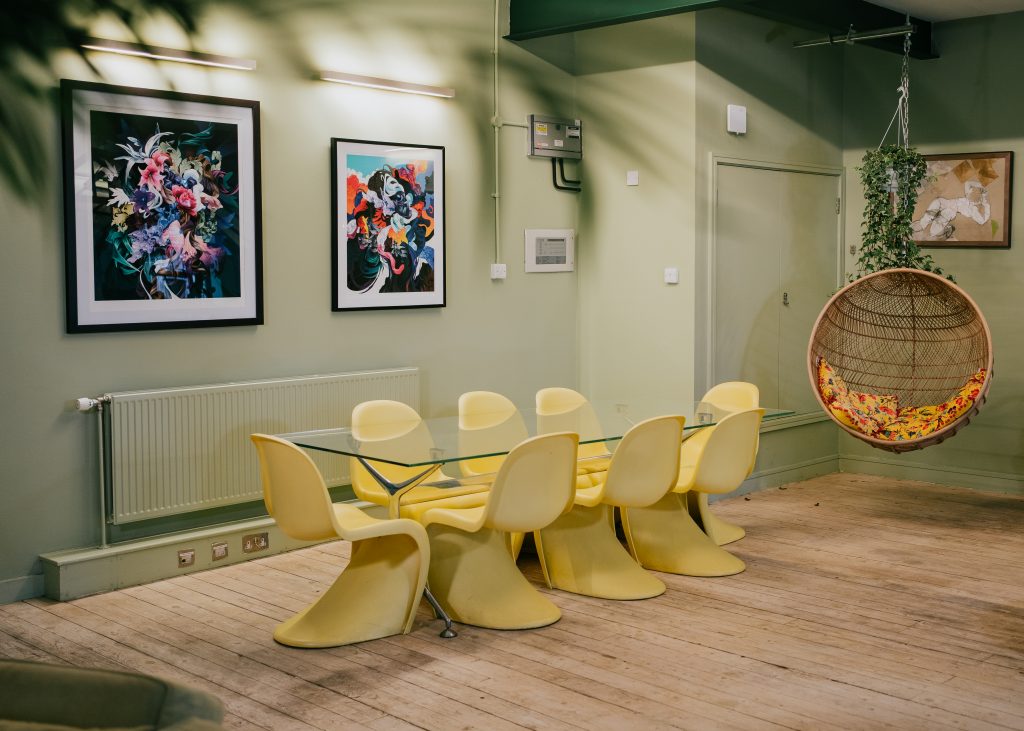 a glass table with yellow chairs around it